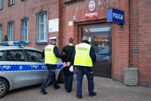 Policjanci prowadzą podejrzanego.