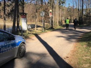 Policjant z żołnierzem patrolują okolice jeziora.
