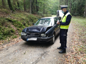Policjant dokumentuje uszkodzenia pojazdu.